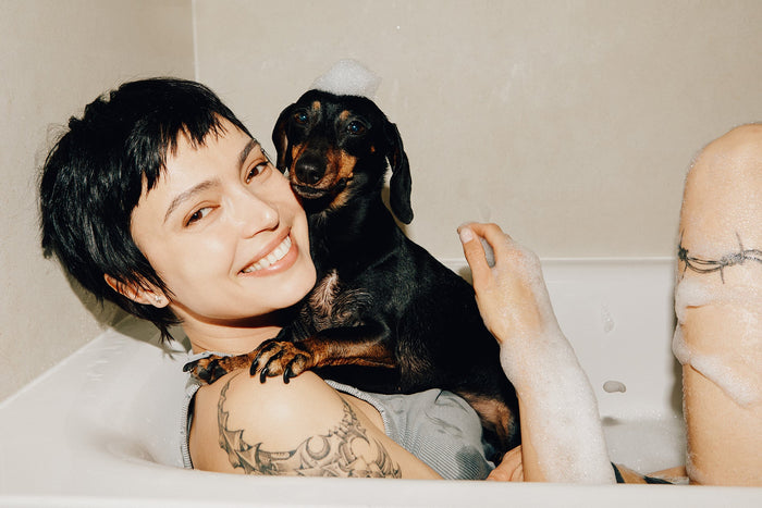 Photo image of a woman in the bath with her dog.